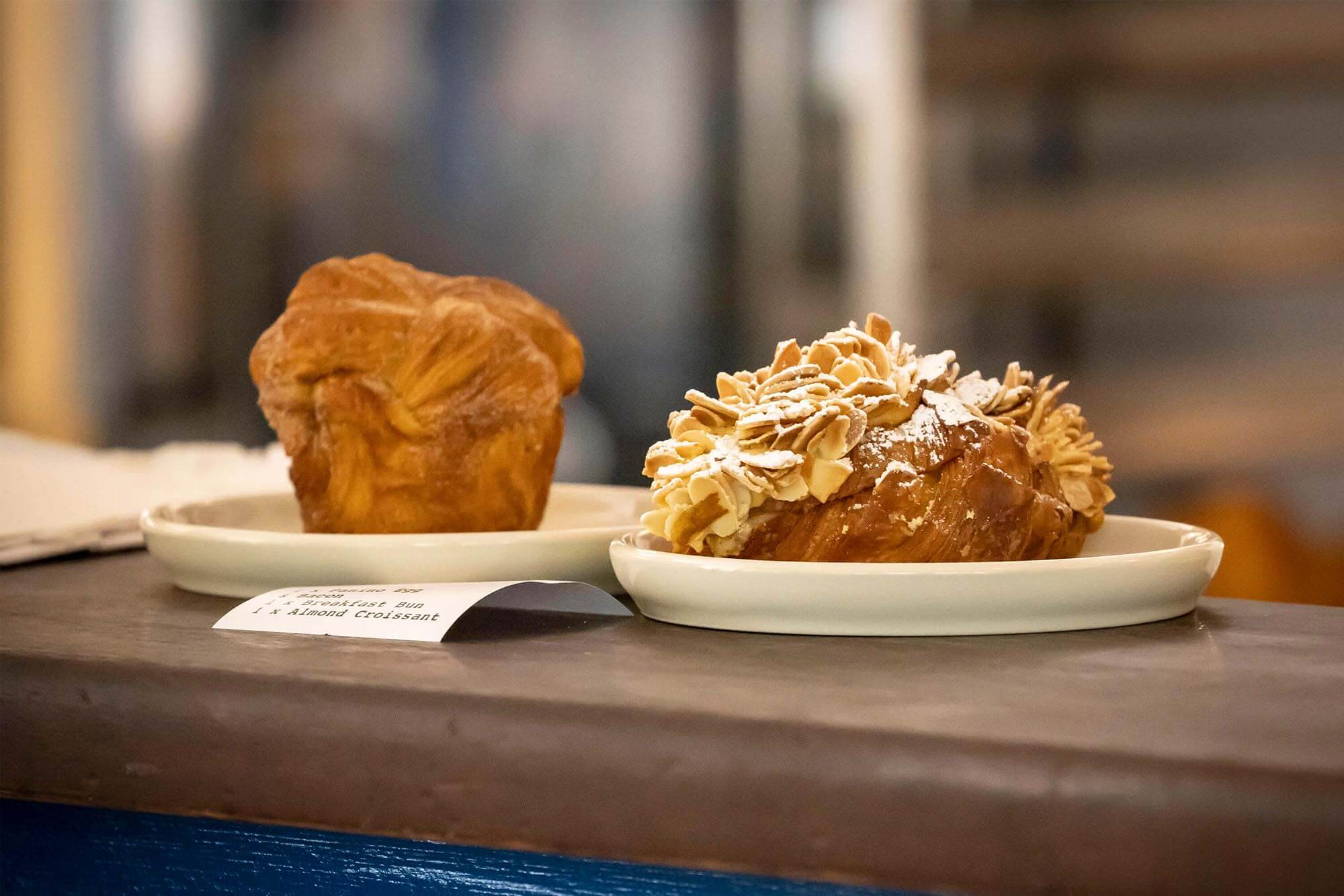 A breakfast bun and almond croissant ready to be served